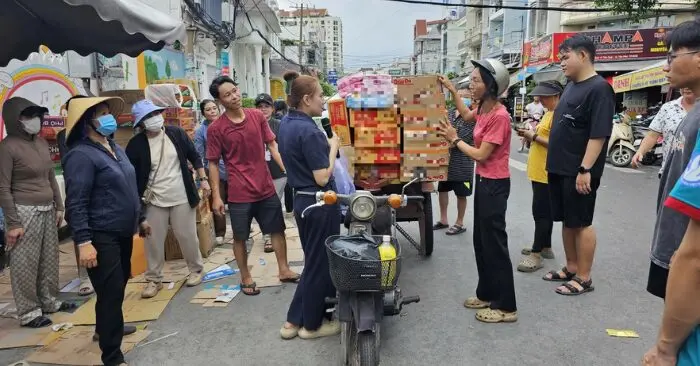 người phụ nữ bán rau chở hàng cứu trợ