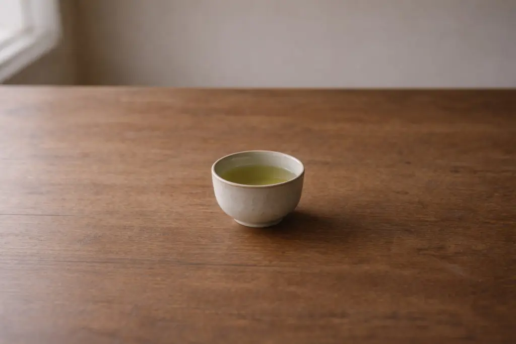 Chén chè xanh màu nhạt đặt giữa khoảng trống rộng.