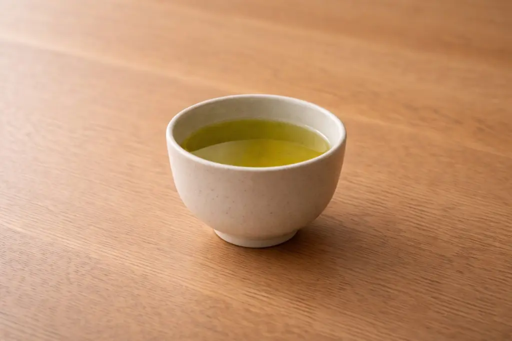 Chén chè xanh nhìn từ trên xuống, ánh sáng dịu.