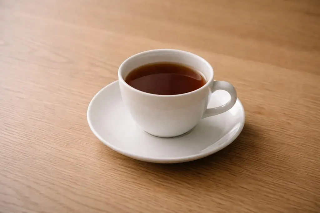 Chén trà đen nhìn từ trên xuống, ánh sáng dịu.