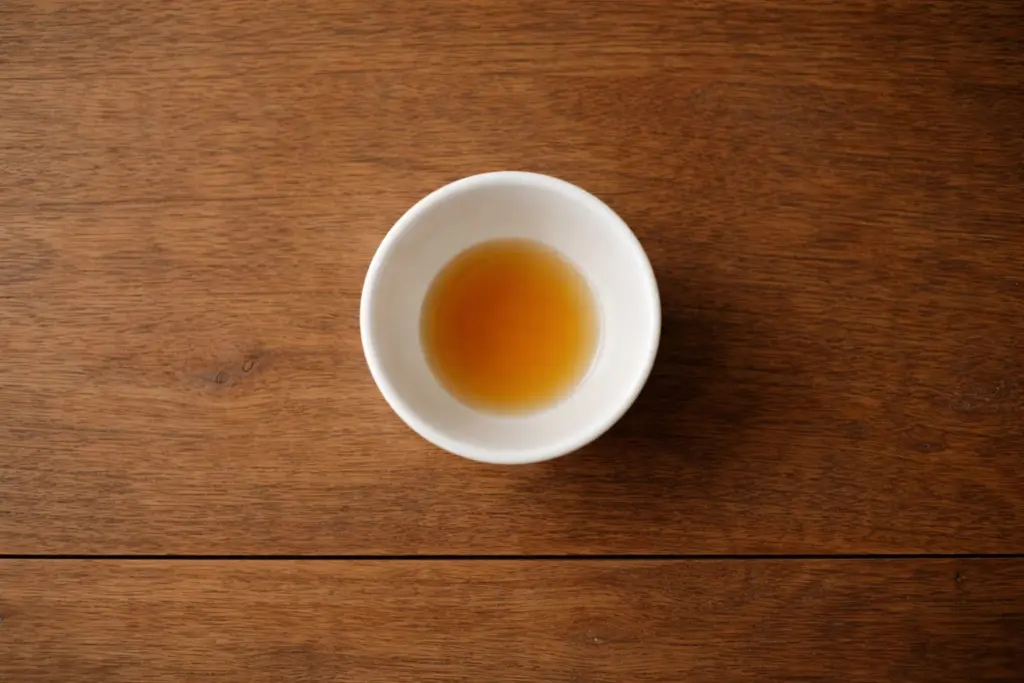 Chén trà còn một ít nước đáy nhìn từ trên xuống trên bàn gỗ