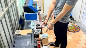 Đối tượng Huỳnh Quốc Thanh bị bắt giữ trong vụ làm tiền giả cùng các công cụ, thiết bị phục vụ việc làm tiền giả.