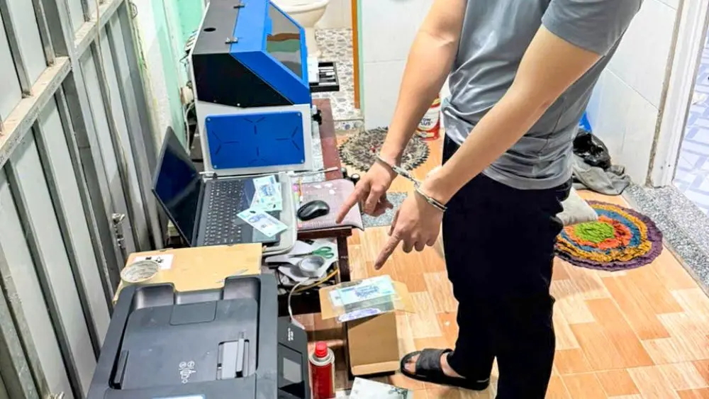 Đối tượng Huỳnh Quốc Thanh bị bắt giữ trong vụ làm tiền giả cùng các công cụ, thiết bị phục vụ việc làm tiền giả.