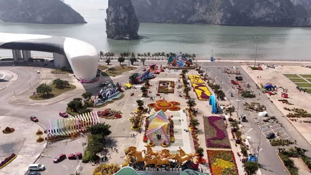 Quảng Ninh định hướng kiểm soát xây dựng, hạn chế công trình ảnh hưởng tầm nhìn Vịnh Hạ Long, gắn phát triển đô thị với bảo tồn di sản. 2. Tiêu đề Vịnh Hạ Long được ưu tiên bảo tồn trong đô thị mới 3. Chú thích Đường hoa tạo không gian cảnh quan bên vịnh Hạ Long, Quảng Ninh. (Ảnh minh họa: TNM) 4. Mô tả (alt text) Đường hoa ven vịnh Hạ Long với cảnh quan đô thị và mặt nước phía xa.