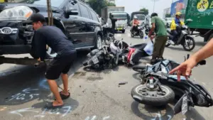 Ôtô Mercedes tông 3 xe máy dừng đèn đỏ ở TP HCM, khiến 2 người bị thương, giao thông qua khu vực ùn tắc.