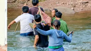 Người dân Dốc Mây vượt suối, khiêng người bị rắn cắn ra ngoài cấp cứu, thể hiện tinh thần tương trợ giữa vùng núi hiểm trở.