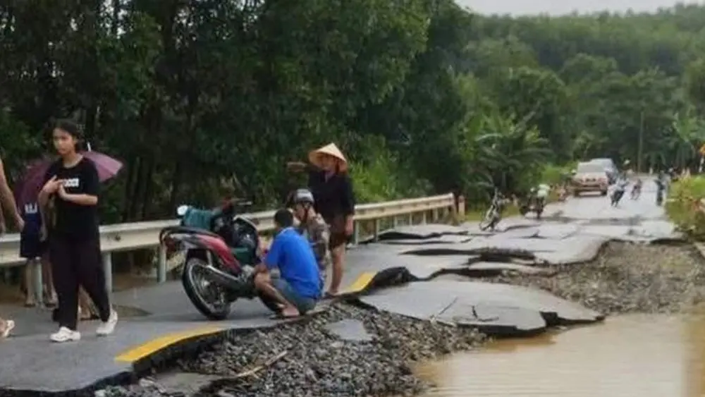 Mặt đường quốc lộ 48E ở Nghệ An bị nước lũ khoét sâu, cuốn trôi vật liệu phía dưới, để lộ lớp đá cấp phối sau khi nước rút.