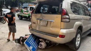 Ô tô Prado lùi bất ngờ trên đường Lê Duẩn, Hà Nội, cuốn xe máy chở hai phụ nữ vào gầm, khiến hai phương tiện hư hỏng.